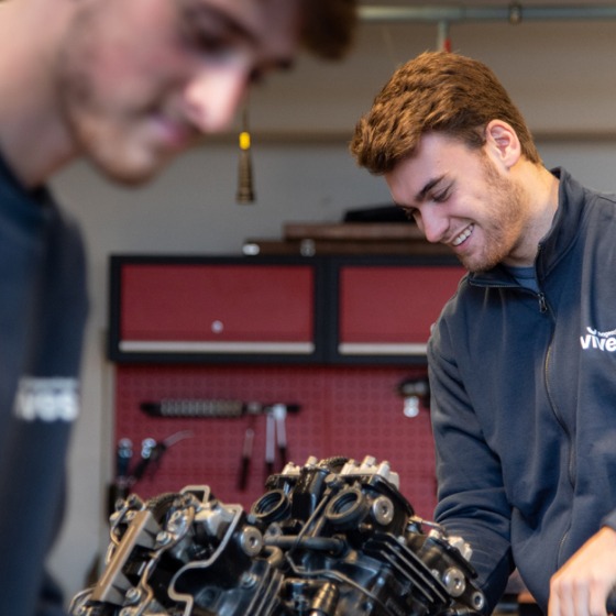 Studenten autotechnologie werken aan motor in labo