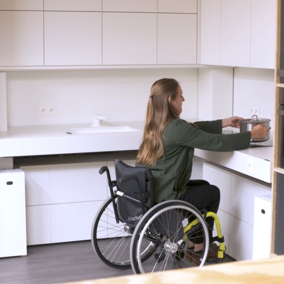 Vrouw in rolstoel in keuken
