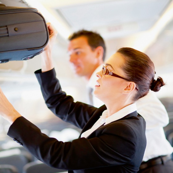 Stewardess bergt bagage op