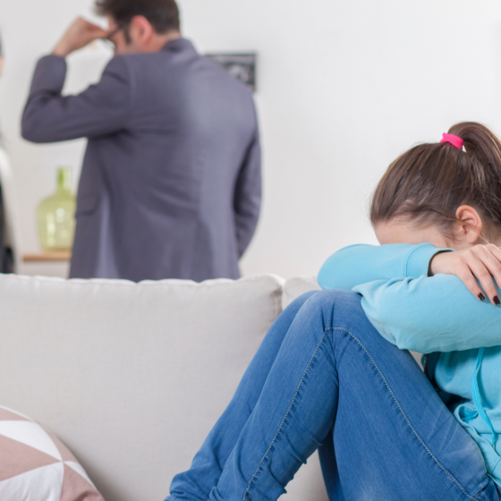 Verdrietig meisje met ruzie makenede ouders